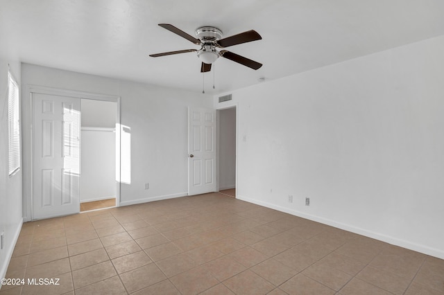 spare room with ceiling fan and light tile patterned flooring