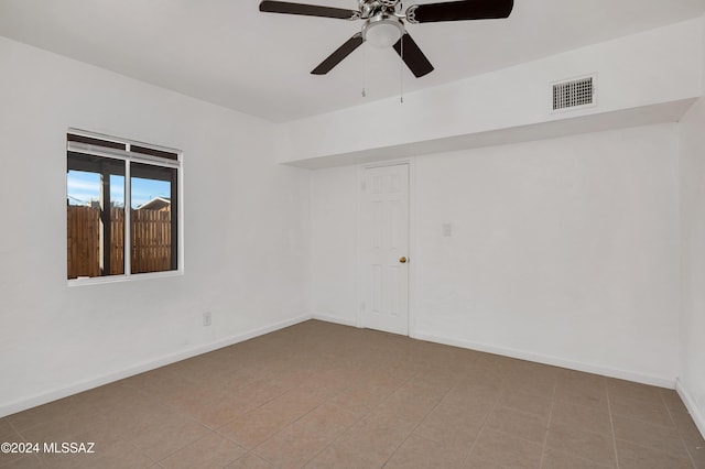 tiled empty room featuring ceiling fan