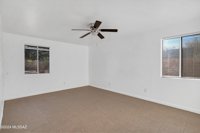 tiled empty room with ceiling fan and a healthy amount of sunlight