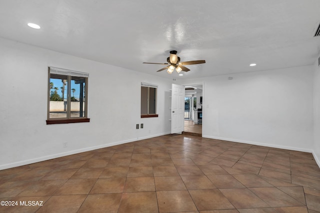 tiled empty room featuring ceiling fan