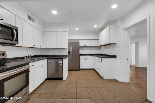 kitchen featuring white cabinets, light tile patterned floors, stainless steel appliances, and sink