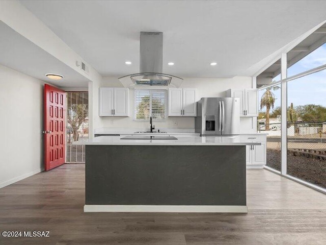 kitchen featuring dark hardwood / wood-style floors, island exhaust hood, white cabinetry, and stainless steel refrigerator with ice dispenser