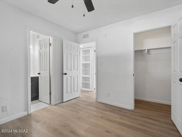 unfurnished bedroom with ceiling fan, a closet, ensuite bath, and light hardwood / wood-style flooring