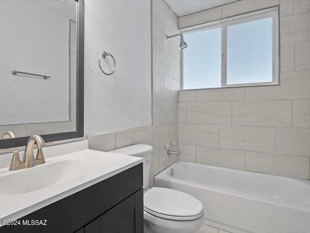 full bathroom featuring vanity, tiled shower / bath combo, toilet, and tile walls