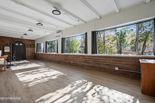 interior space with beamed ceiling and a wall unit AC