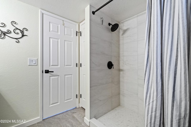 bathroom with a shower with curtain and a textured ceiling