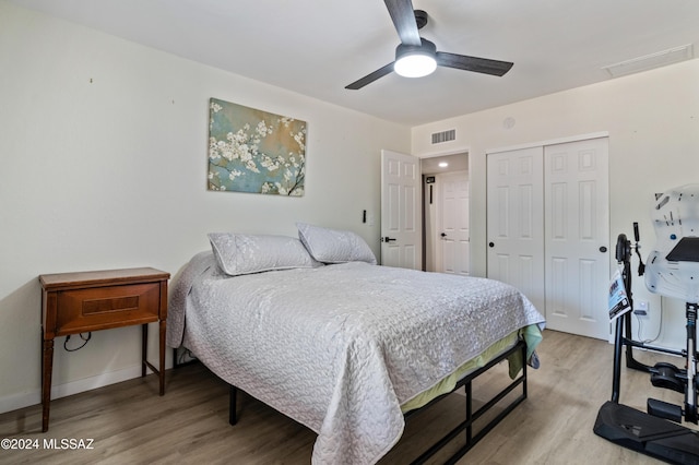 bedroom with a closet, hardwood / wood-style flooring, and ceiling fan