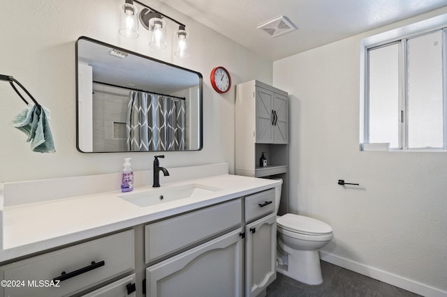 bathroom featuring vanity, toilet, and walk in shower