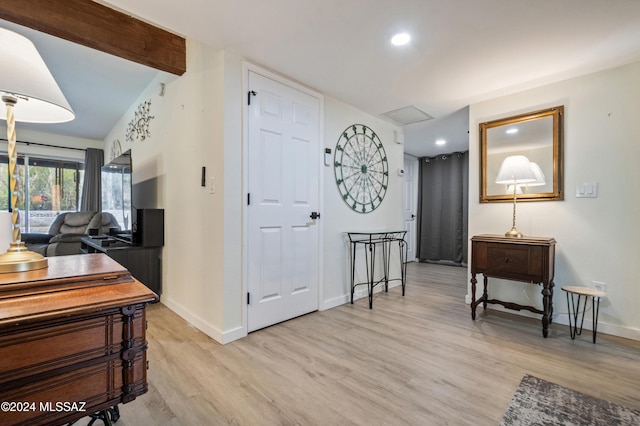 foyer featuring vaulted ceiling with beams and light wood-type flooring