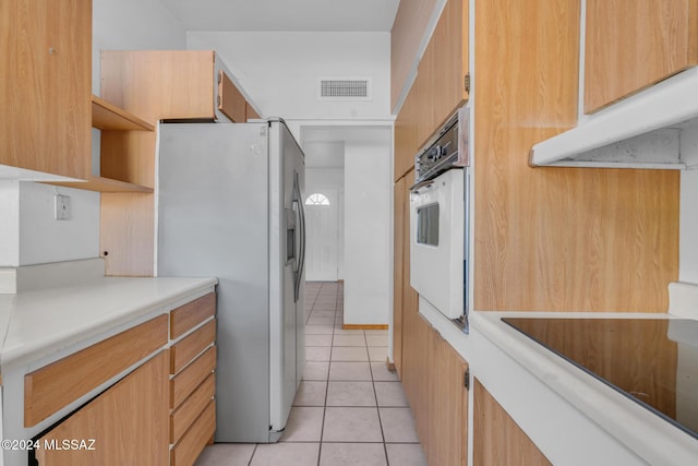 kitchen featuring light tile patterned flooring, stainless steel refrigerator with ice dispenser, and white oven