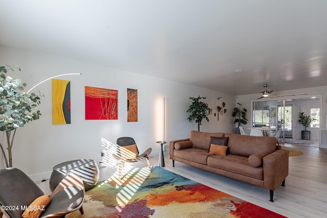 living room featuring ceiling fan and light hardwood / wood-style floors