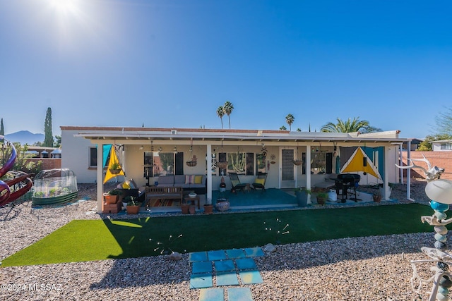 rear view of property featuring a lawn and a patio