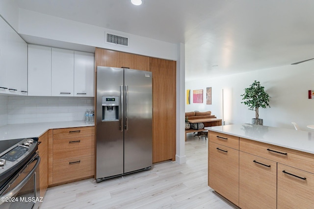 kitchen with backsplash, white cabinets, light hardwood / wood-style flooring, black electric range, and stainless steel fridge