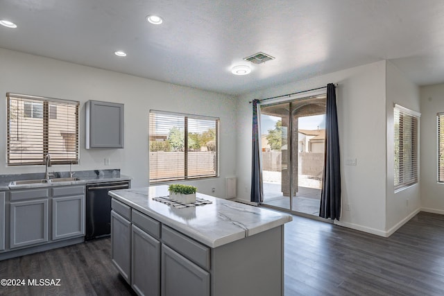 kitchen featuring dishwasher, a center island, sink, and dark wood-type flooring