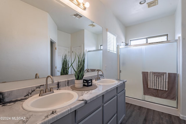 bathroom with hardwood / wood-style flooring, vanity, and a shower with door