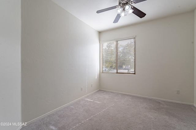 spare room featuring light colored carpet and ceiling fan