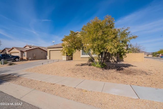 view of property hidden behind natural elements featuring a garage