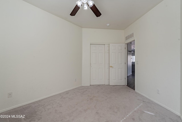 unfurnished bedroom featuring light carpet, a closet, and ceiling fan