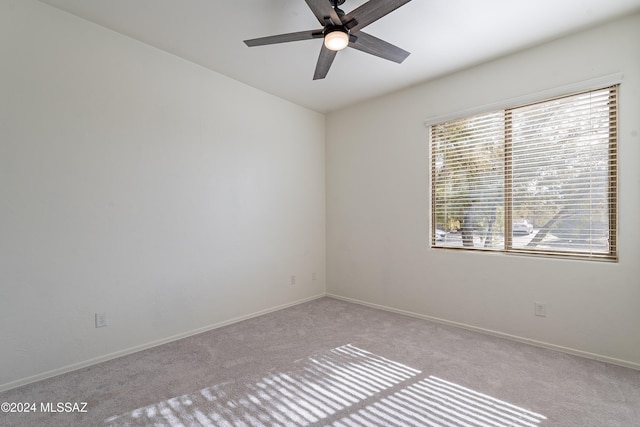 empty room featuring light colored carpet, ceiling fan, and a healthy amount of sunlight