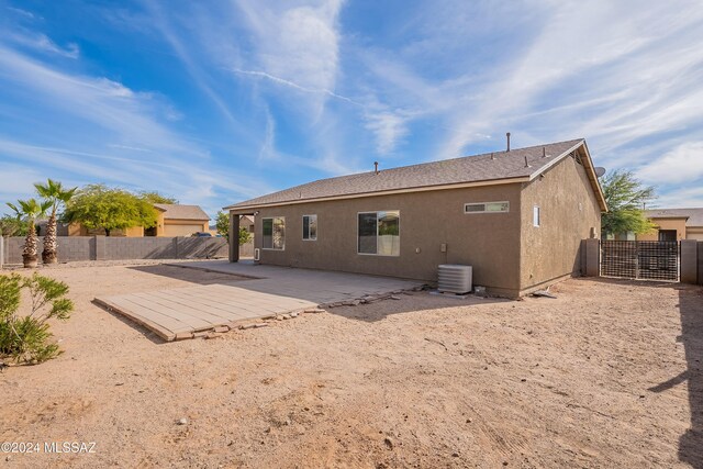 rear view of house with central AC unit and a patio area