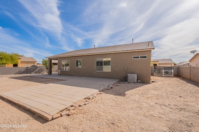 back of property with central air condition unit and a patio