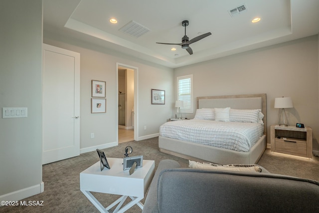 bedroom featuring ceiling fan, carpet floors, and a tray ceiling