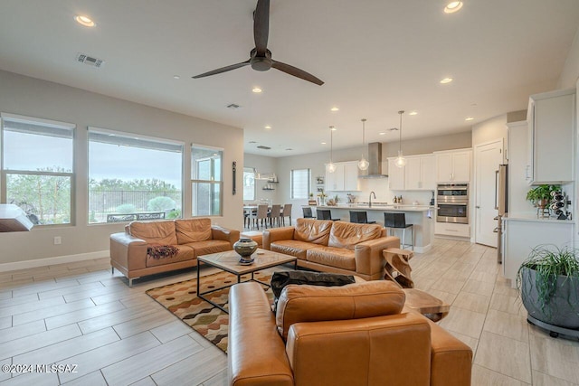 living room with ceiling fan and sink