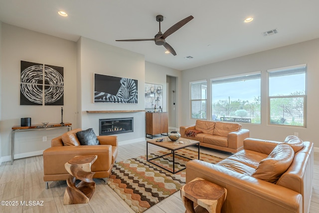 living room with light hardwood / wood-style flooring and ceiling fan