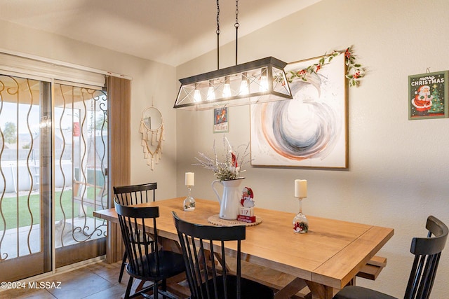 dining space with tile patterned flooring and lofted ceiling