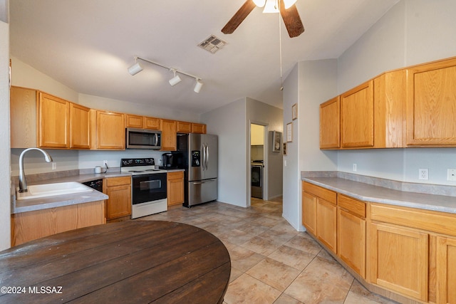 kitchen with rail lighting, stainless steel appliances, ceiling fan, and sink