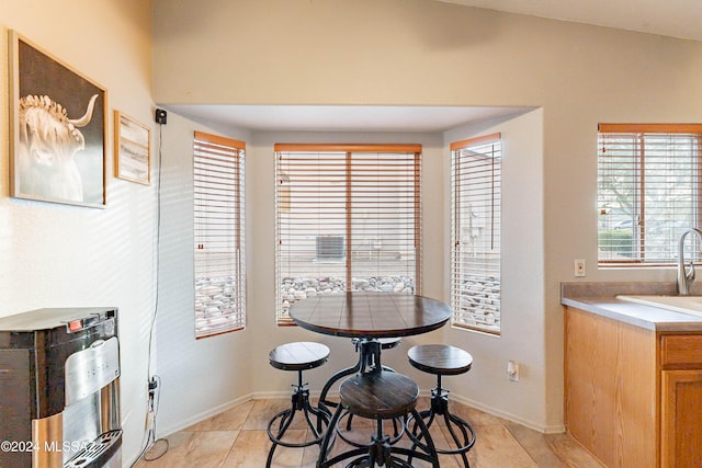 dining space with lofted ceiling and light tile patterned flooring