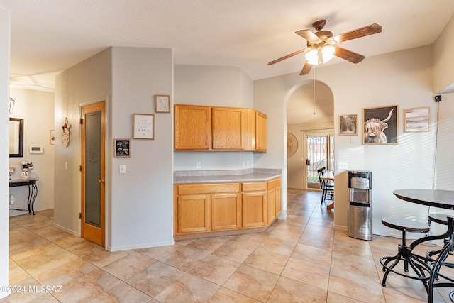 kitchen with ceiling fan, light tile patterned flooring, and lofted ceiling