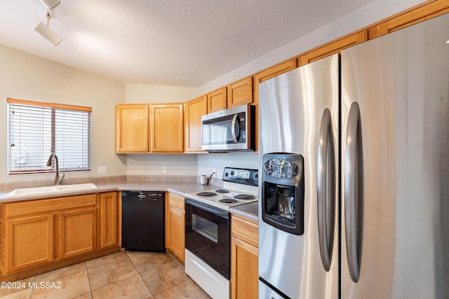 kitchen featuring lofted ceiling, sink, a textured ceiling, appliances with stainless steel finishes, and light tile patterned flooring