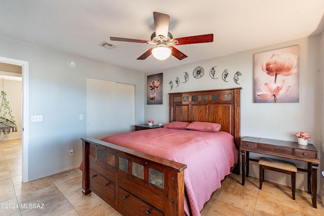 bedroom featuring ceiling fan, light tile patterned floors, and a closet