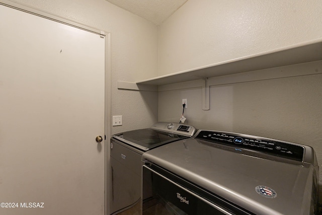 laundry room with independent washer and dryer and a textured ceiling