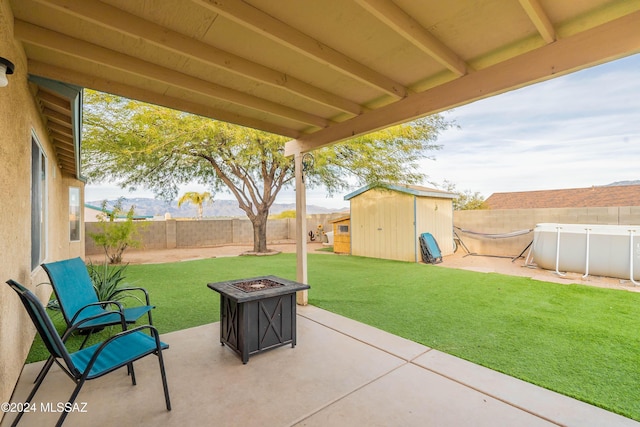 view of patio with a fire pit and a storage shed