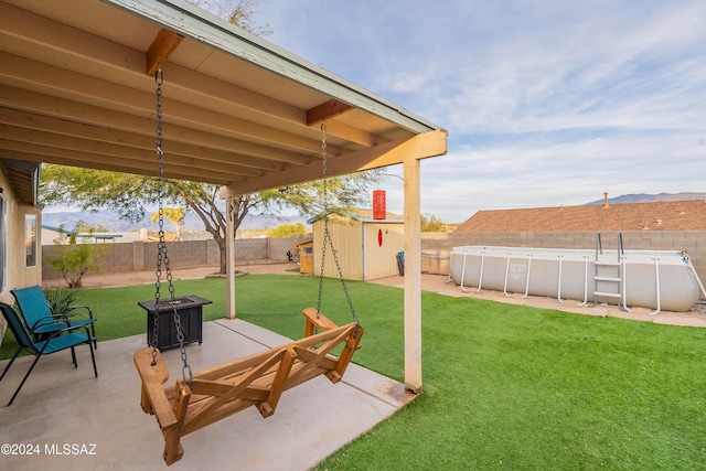 view of yard featuring a fenced in pool and a storage shed