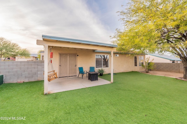 back of property featuring a yard and a patio area