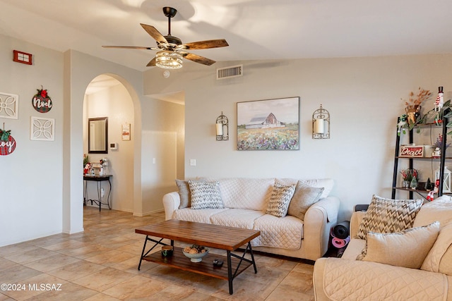 tiled living room with ceiling fan and vaulted ceiling