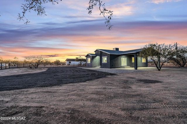 property exterior at dusk with a patio