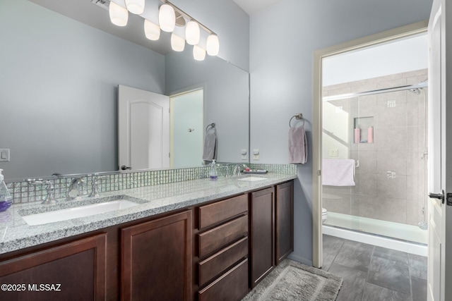 bathroom with a shower with door, vanity, and toilet