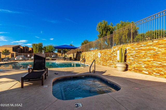 view of pool featuring a patio area and a hot tub