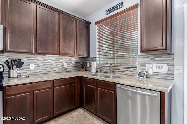 kitchen with light stone countertops, sink, stainless steel dishwasher, backsplash, and dark brown cabinets