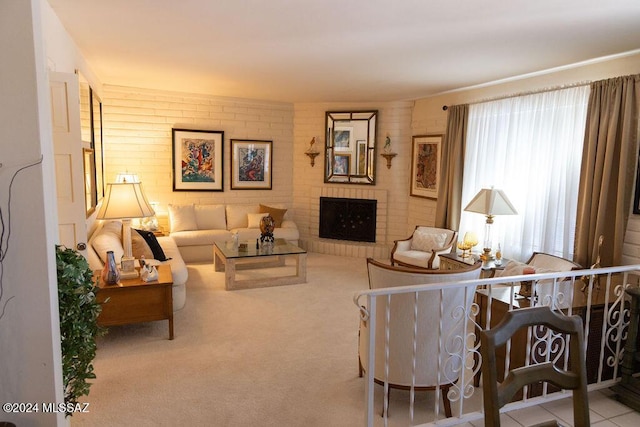 living room with light carpet, brick wall, and a brick fireplace