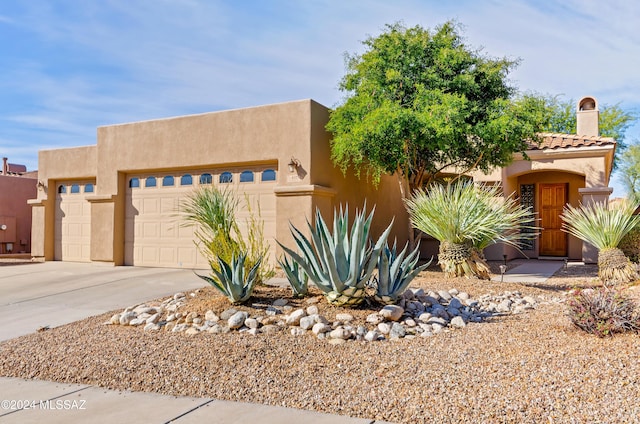 pueblo-style house featuring a garage