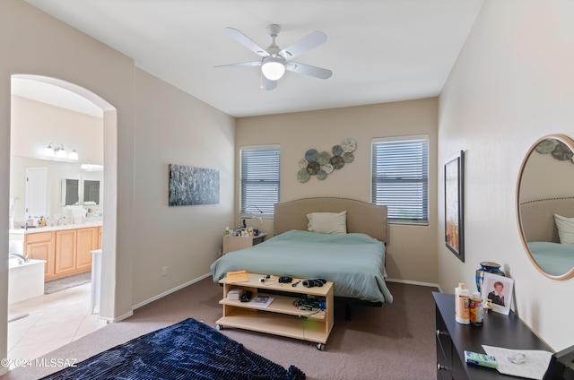 bedroom featuring ensuite bath, ceiling fan, and light carpet