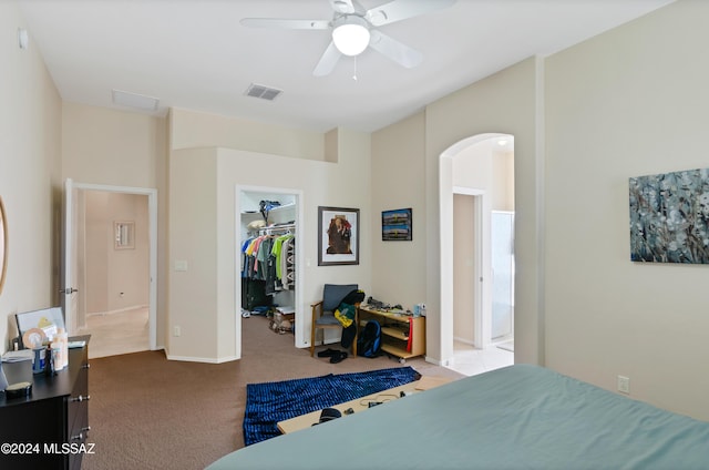 carpeted bedroom featuring ceiling fan, a closet, and a spacious closet