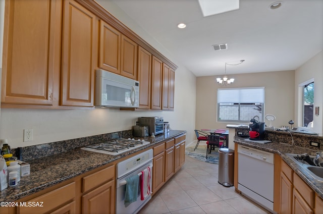 kitchen with hanging light fixtures, white appliances, a wealth of natural light, and a notable chandelier