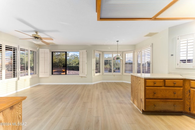 kitchen featuring pendant lighting, ceiling fan, and light hardwood / wood-style flooring