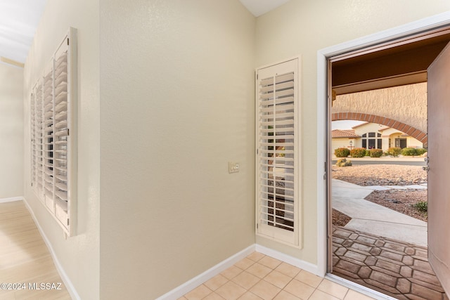 doorway to outside with a mail area and light tile patterned floors